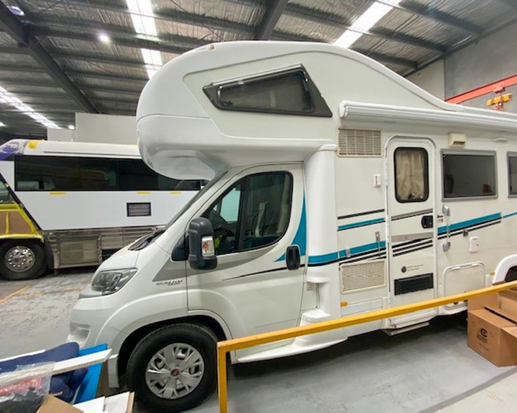 Side view of motorhome waiting to be repaired