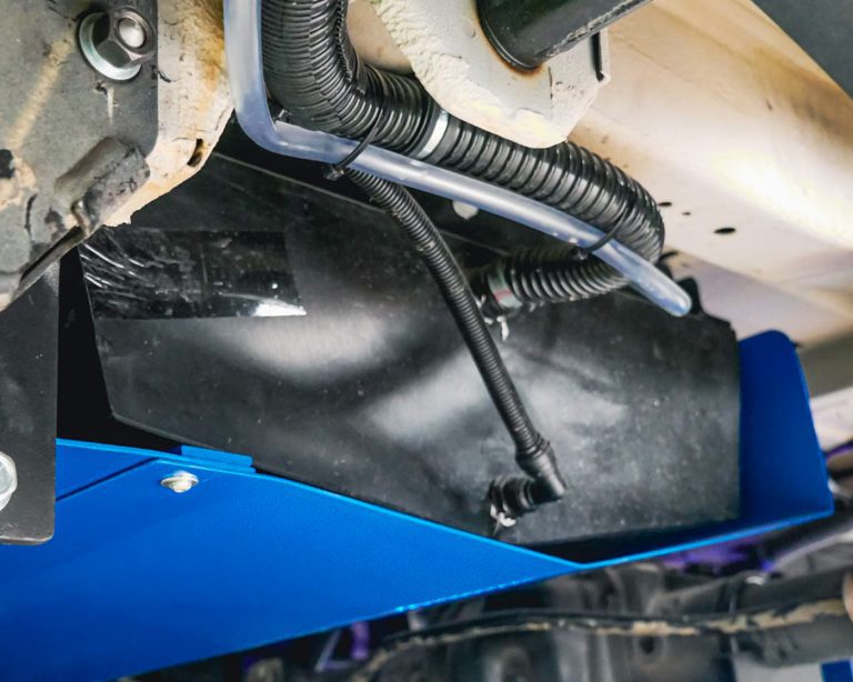 Water tank with rock guard on van conversion motorhome